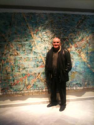 Ο Παιδίατρος Ε. Ευαγγελάτος που ασχολείται με τα εικαστικά μπροστά απο έργο του καλλιτέχνη