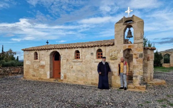 Με τον Κώστα Γαλιατσάτο. Ανάμεσά μας ο δικέφαλος και η κτητορική επιγραφή. Στο βάθος, στην μάνδρα, από πέτρινο τόξο κρέμεται άλλη καμπάνα