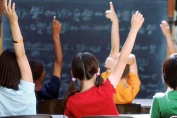 Δασκάλα παραδίδει μαθήματα σε παιδιά Δημοτικού